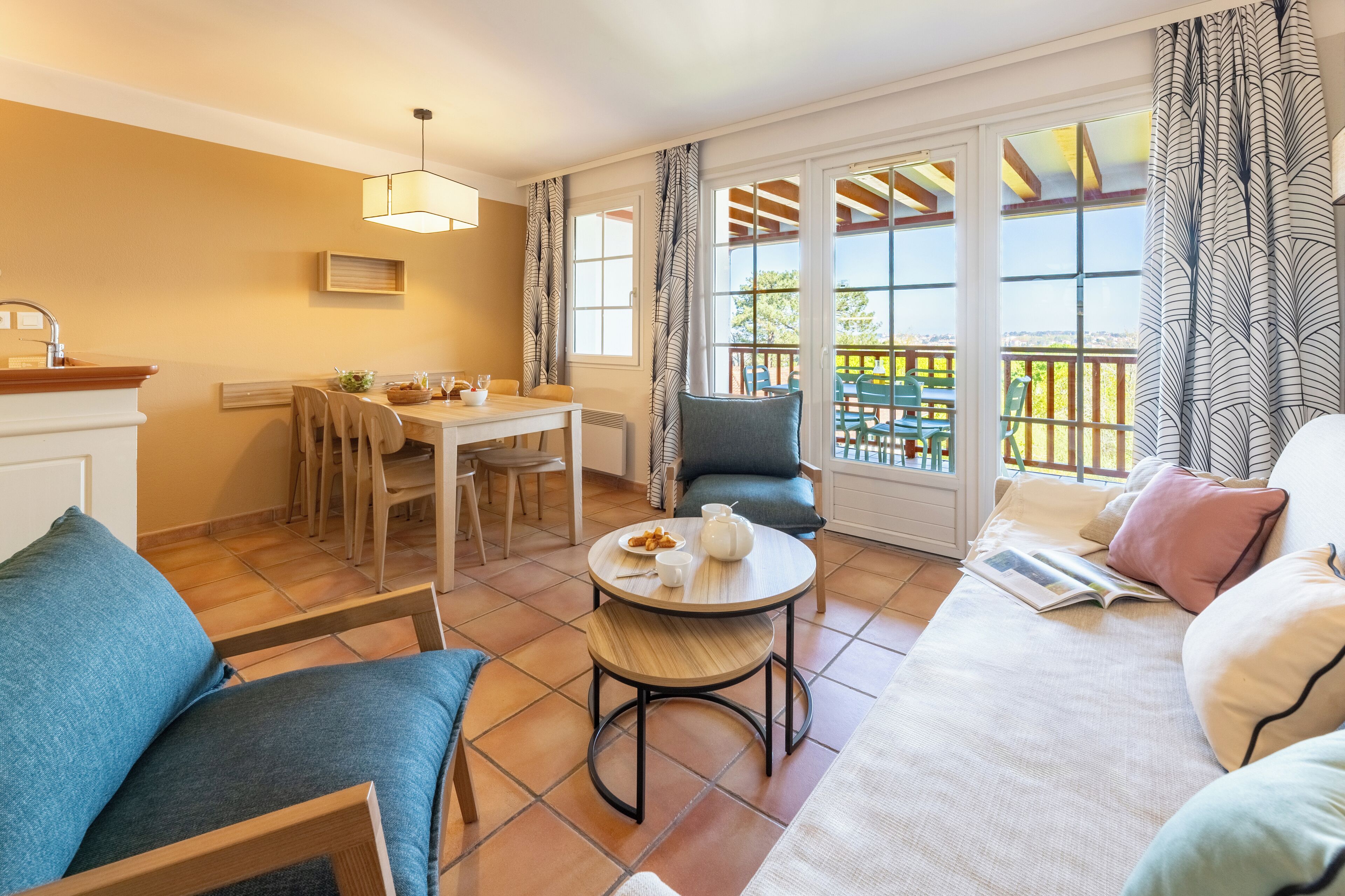 Una sala acogedora con sofá, una mesa de comedor y un balcón con vistas.