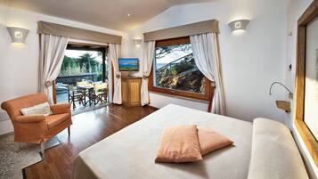 Un dormitorio con cama, una silla, un escritorio y vistas al exterior.