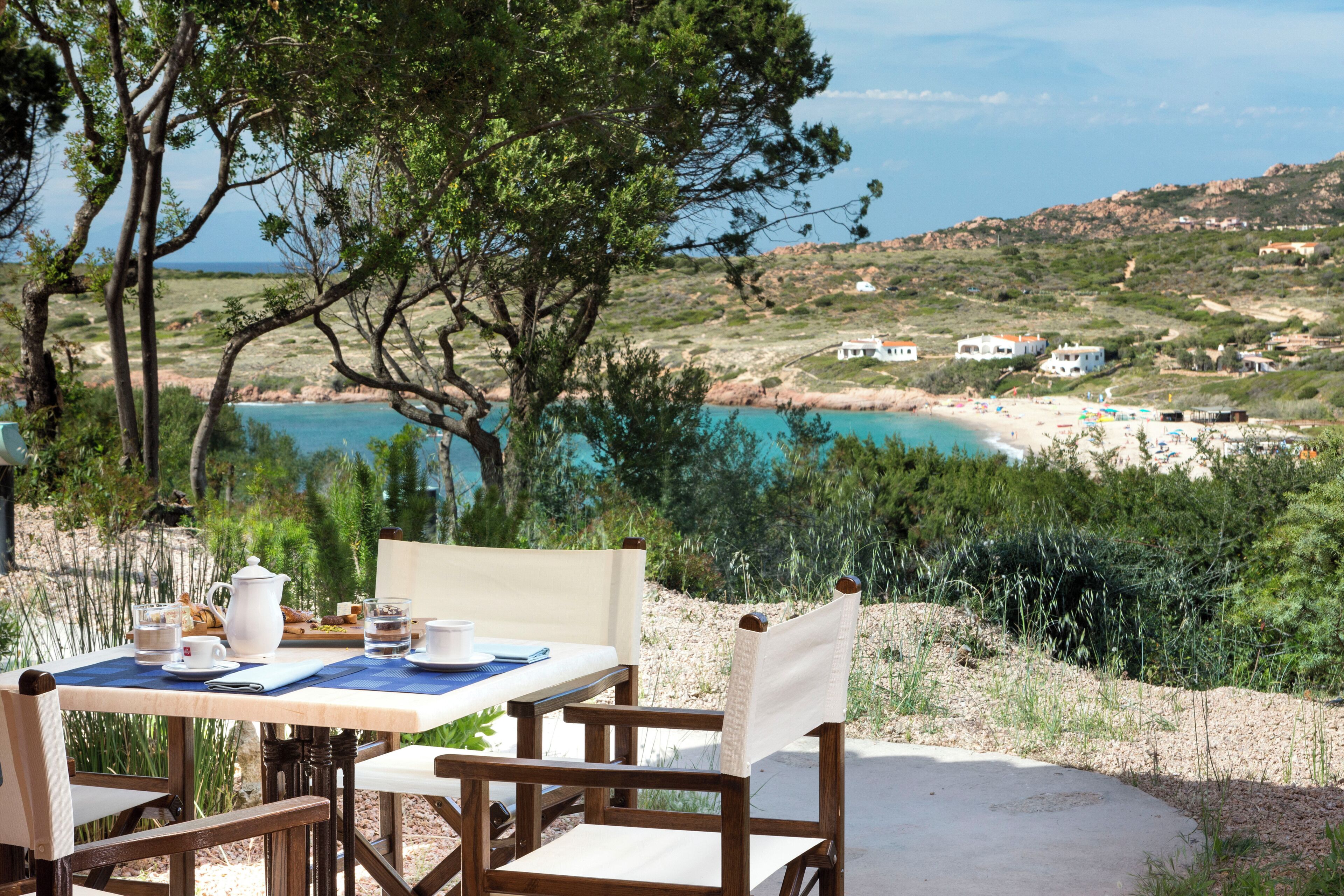 Mesa al aire libre con vista a la playa y colinas.