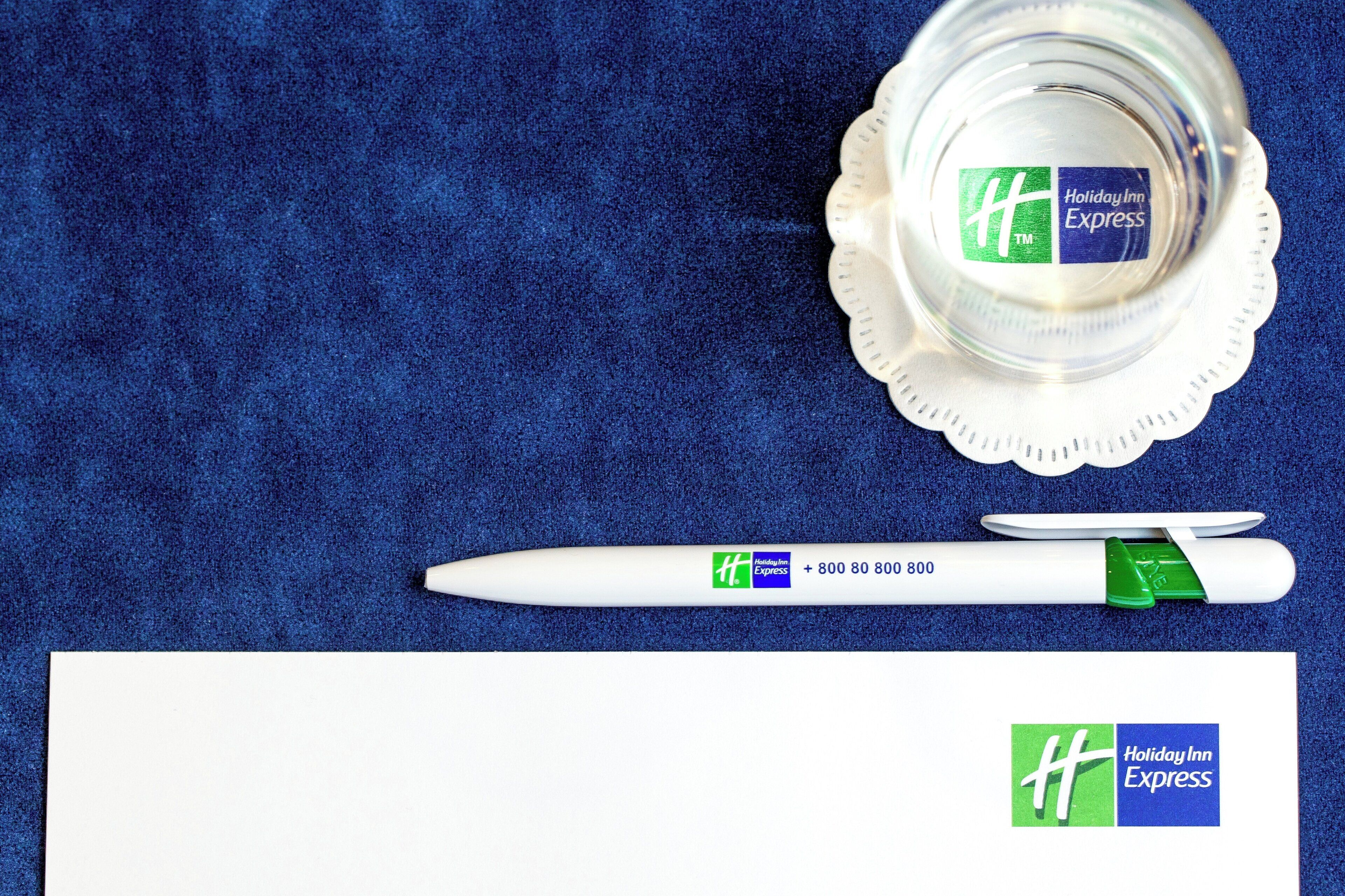 A white pen with a green and blue Holiday Inn Express logo and a white card with the same logo.