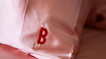A close-up of a pillow with a red embroidered letter 'B'.