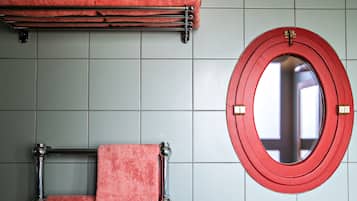 Une salle de bain avec un porte-serviettes, un miroir et des murs carrelés.