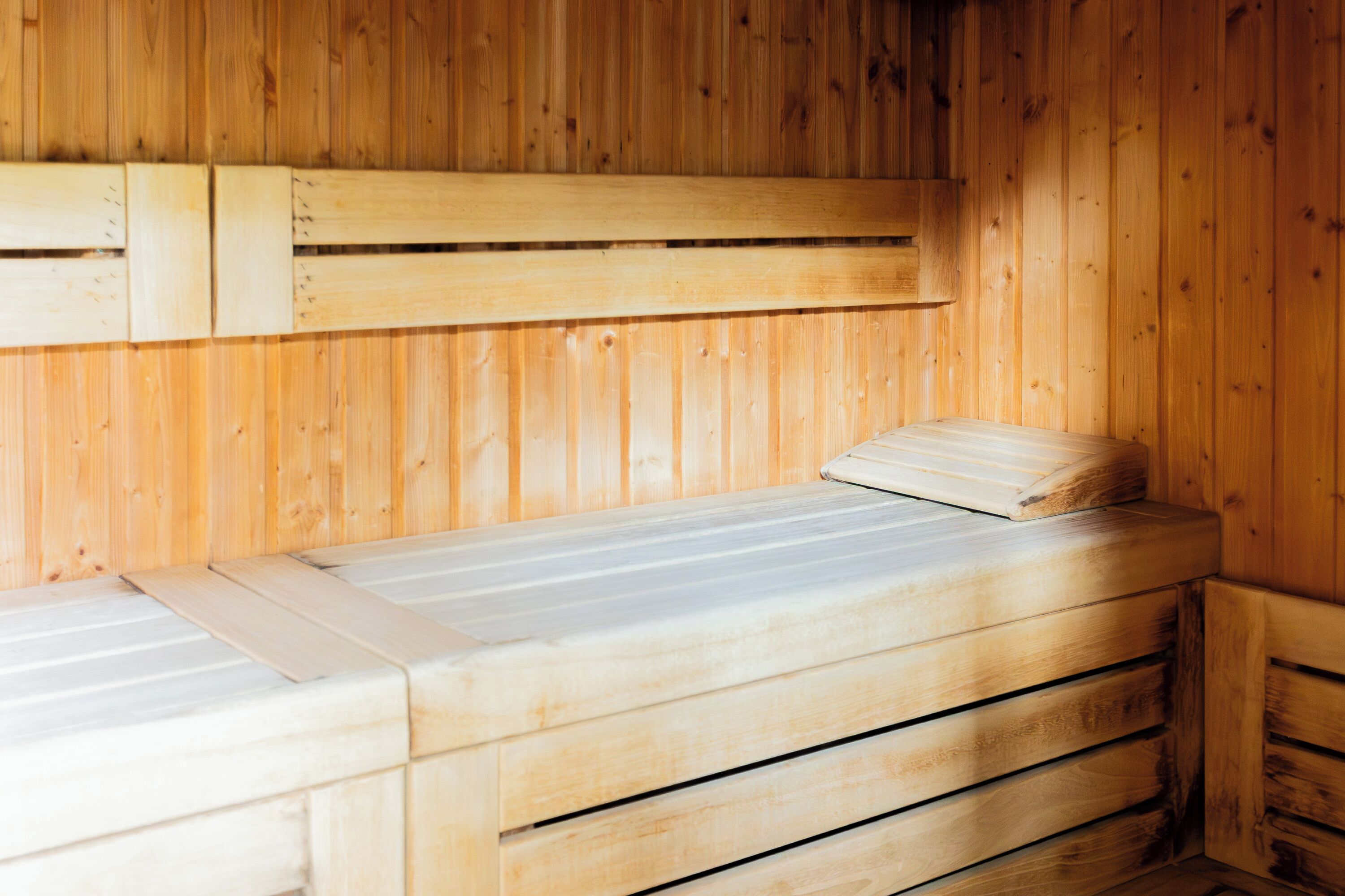 Un sauna en bois, doté de bancs et d’une banquette.