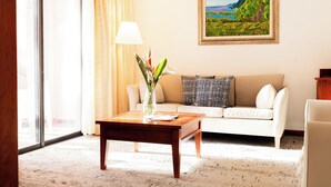 Ein Wohnzimmer mit einer Couch, einem Couchtisch mit einer Vase und einem Gemälde an der Wand.