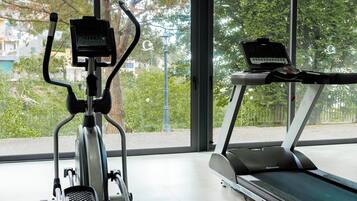 Una palestra al coperto con una cyclette e un tapis roulant.