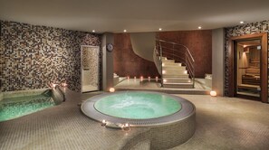 A spa area with a hot tub, a staircase, and a wooden sauna.