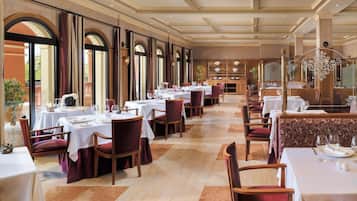 Un restaurant spacieux, doté de nombreuses tables et chaises, de grandes fenêtres et d’un décor intérieur classique.
