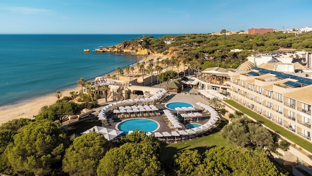 A resort with a large pool area, beach access, and a view of the sea.