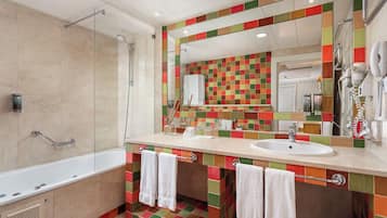 Un baño moderno con una bañera grande, ducha y tocador con un colorido salpicadero de azulejos.