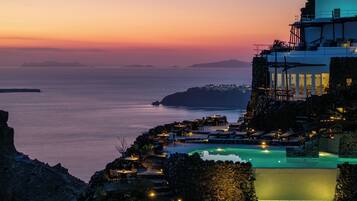 Un hôtel en bord de mer doté d’une piscine, d’un espace extérieur aménagé et offrant une vue sur la mer au coucher du soleil.