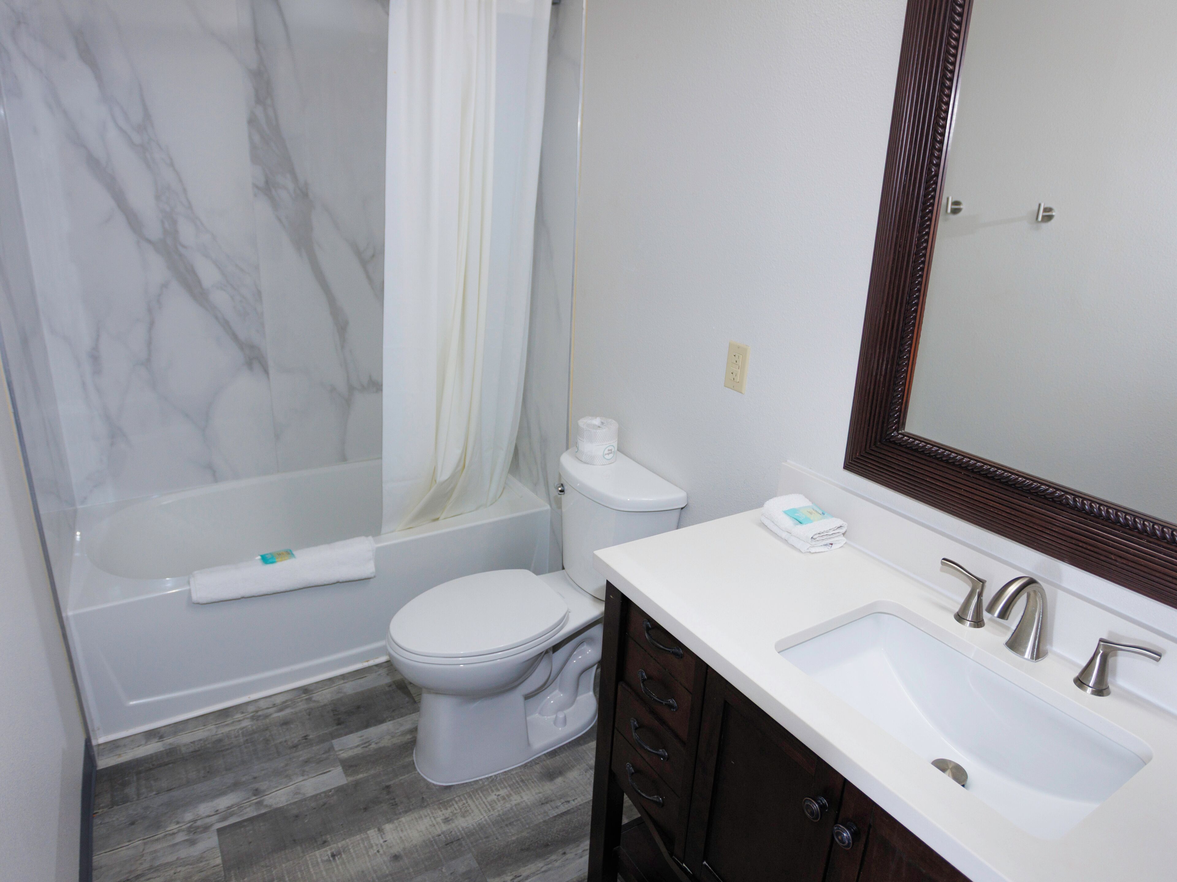 A bathroom with a bathtub, toilet, and sink.