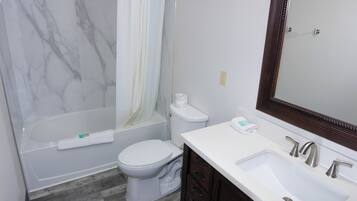 A bathroom with a bathtub, toilet, and sink.