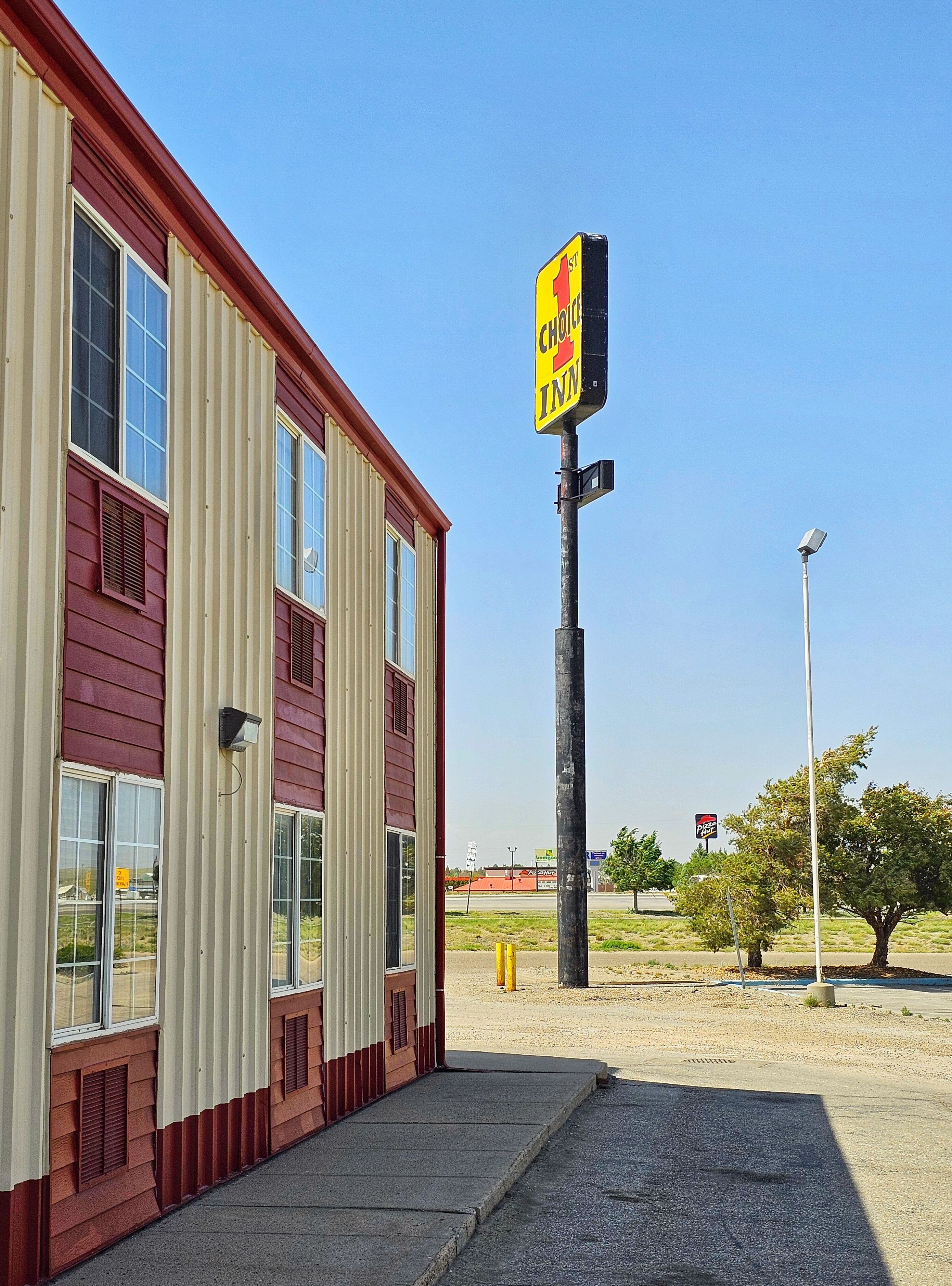 Un edificio con un letrero que dice 'Choc-O-Matic Inn' y un letrero visible de 'Pizza Hut' al fondo.