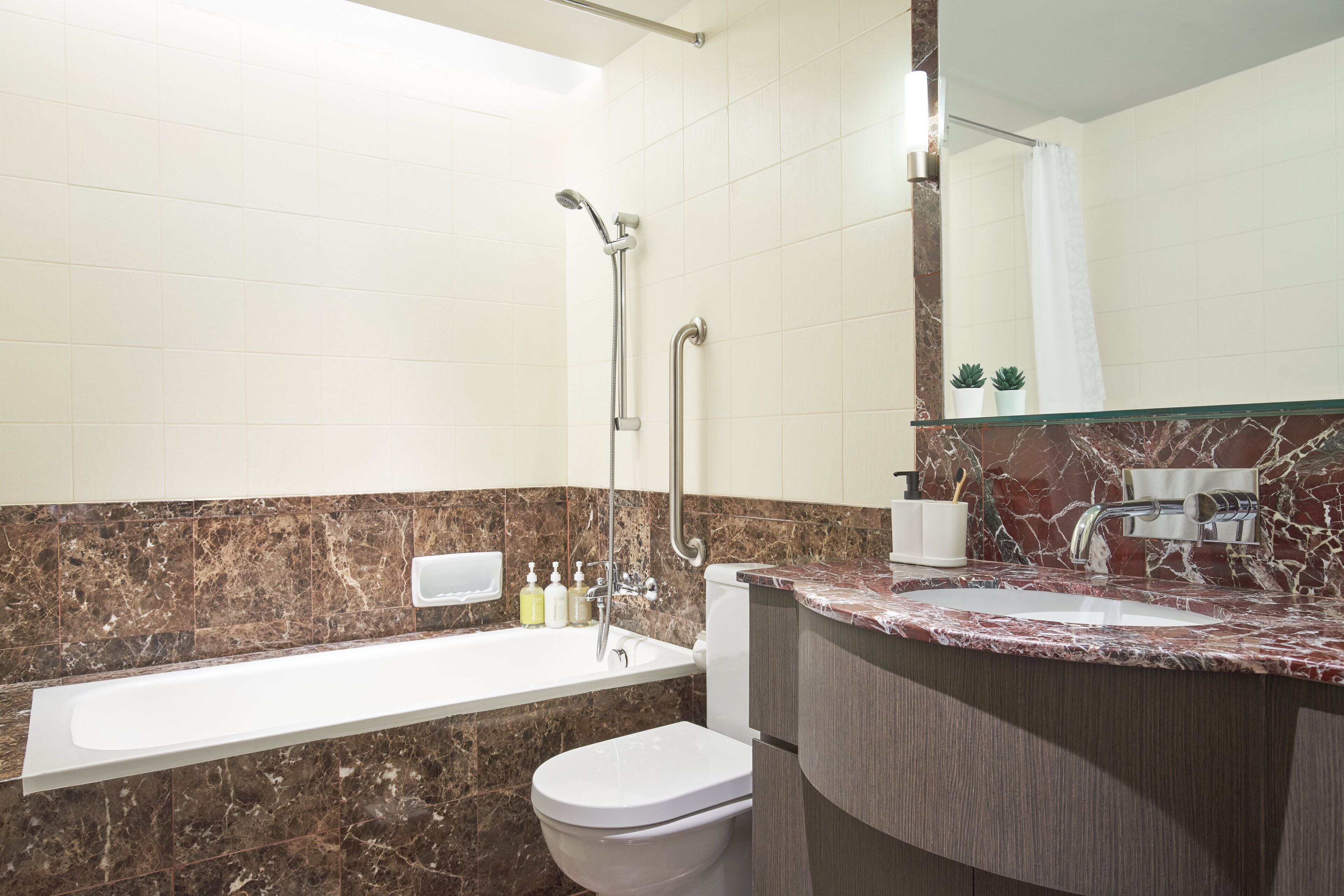A modern bathroom with a bathtub, toilet, and sink.