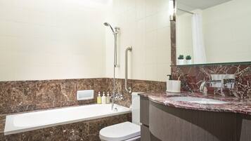 A modern bathroom with a bathtub, toilet, and sink.