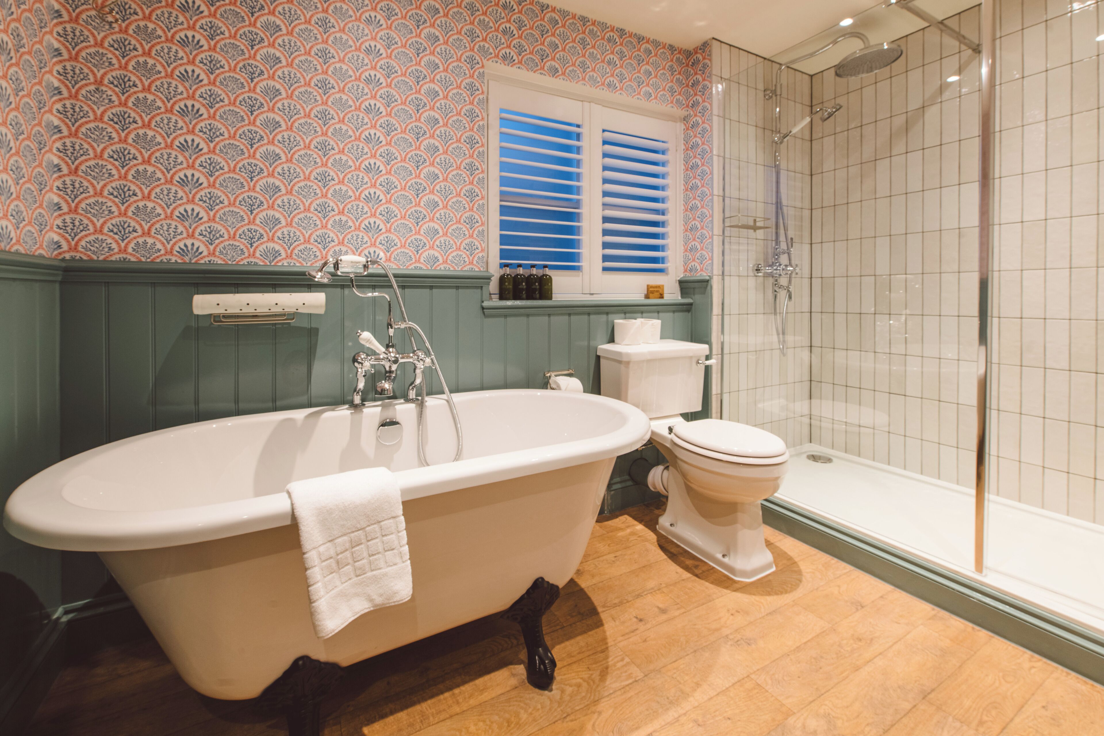A bathroom with a freestanding bathtub, a toilet, and a shower area.