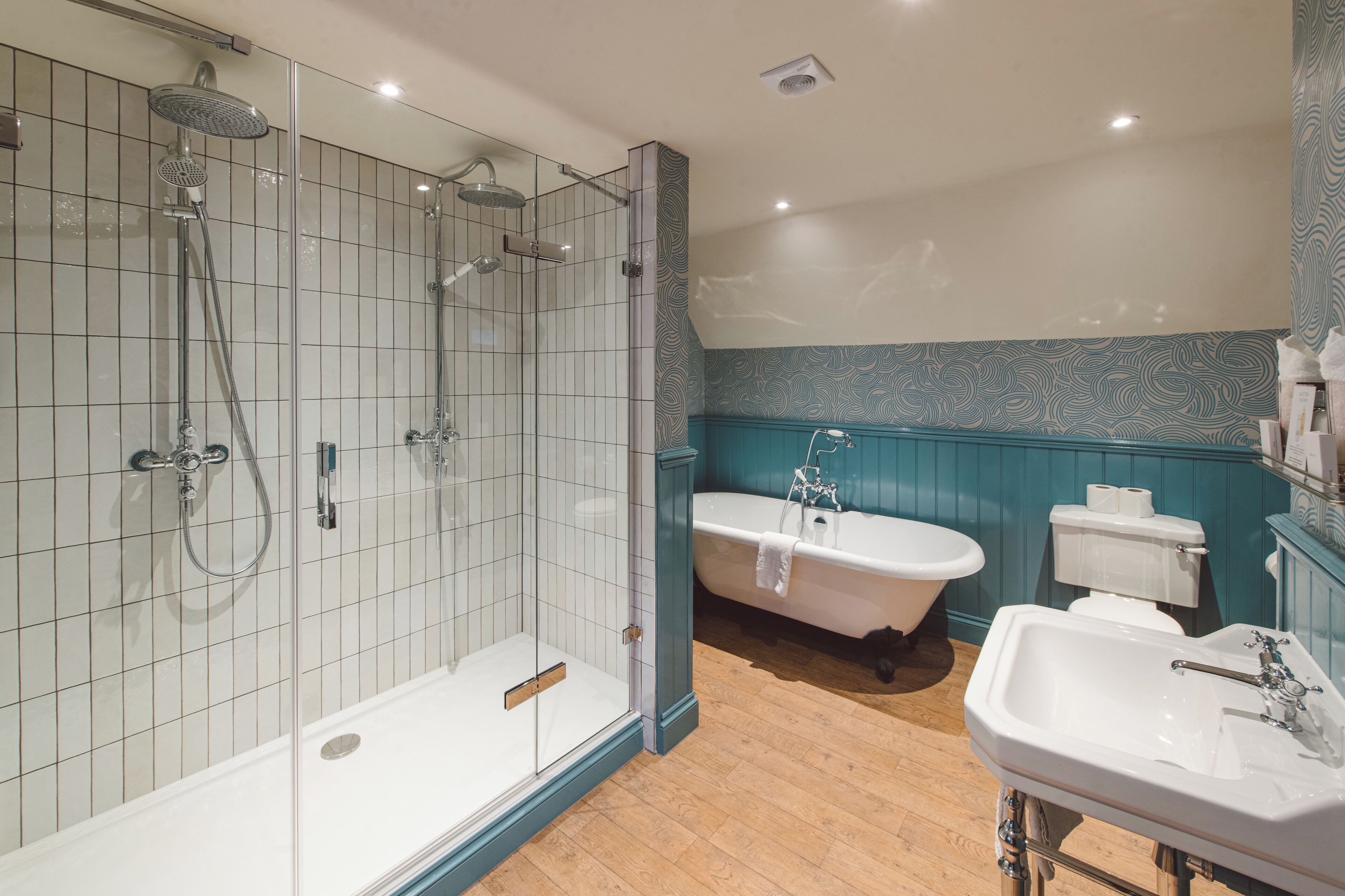 Ein modernes Badezimmer mit einer Glaskabine zur Dusche, einer freistehenden Badewanne und einem Standwaschbecken.