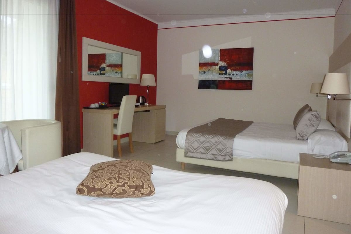 Una habitación de hotel con dos camas, un escritorio y una silla.