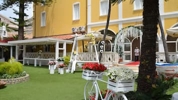 Enjoy a serene outdoor space with a lush lawn, potted plants, and a welcoming bicycle.