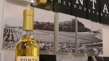 Eine Flasche Zonta Torcolato Wein mit Etikett und einem Hintergrund aus Schwarz-Weiß-Bildern eines Weinbergs, wobei ein Schild mit den Buchstaben "ZONT" teilweise sichtbar ist.