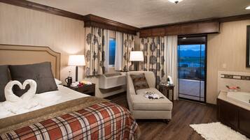 Une chambre d’hôtel avec un lit, un canapé, une petite table avec une lampe, une fenêtre avec des rideaux et une vue sur l’extérieur.