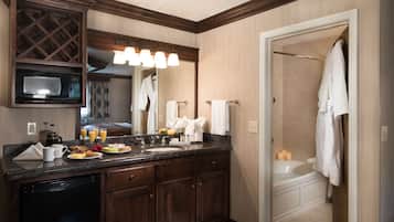 Un baño moderno con tocador de madera oscura, microondas empotrado y ducha con puerta de vidrio.