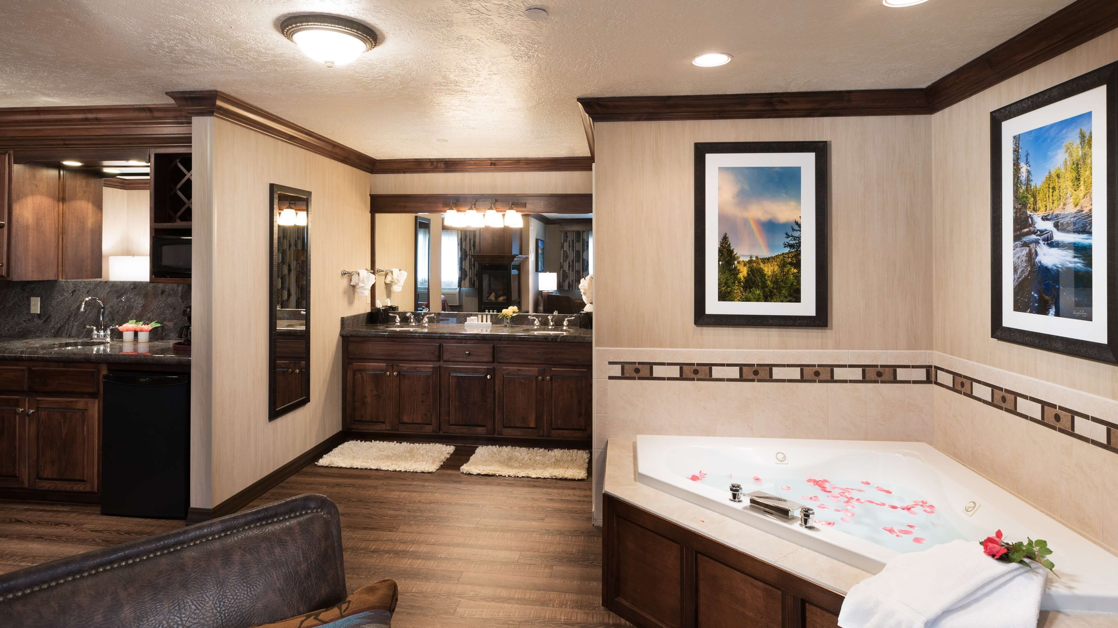 A spacious bathroom with a large bathtub, a separate shower area, and a vanity with a mirror.