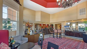 A hotel lobby with a bar, seating area, and a kitchen in the background. - Best Western Mesquite Inn (Mesquite)