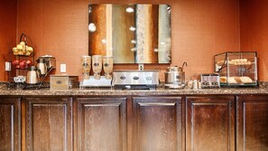 A kitchen counter with coffee makers, a food display, and a coffee pot. - Best Western Mesquite Inn (Mesquite)