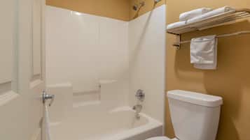 A bathroom with a bathtub, toilet, and towel rack.