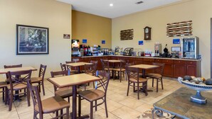 A restaurant with wooden tables and chairs, a counter with a coffee machine, and a decorative wall piece. - Best Western Taylor Inn (Taylor)