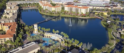 A resort with a central lake, multiple buildings, and a fountain.