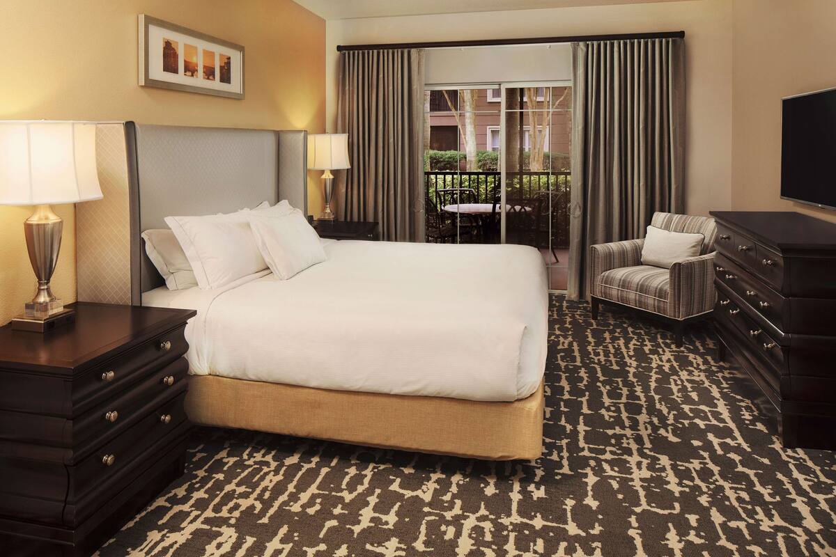 Een hotelkamer met een groot bed, een dressoir, een stoel en een televisie.