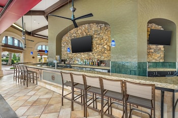 A gym with exercise equipment, a red exercise ball, and a television on the wall. at Hilton Grand Vacations Club Tuscany Village Orlando