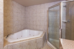 Ein Badezimmer mit freistehender Badewanne, einer Duschkabine aus Glas und gefliesten Wänden.