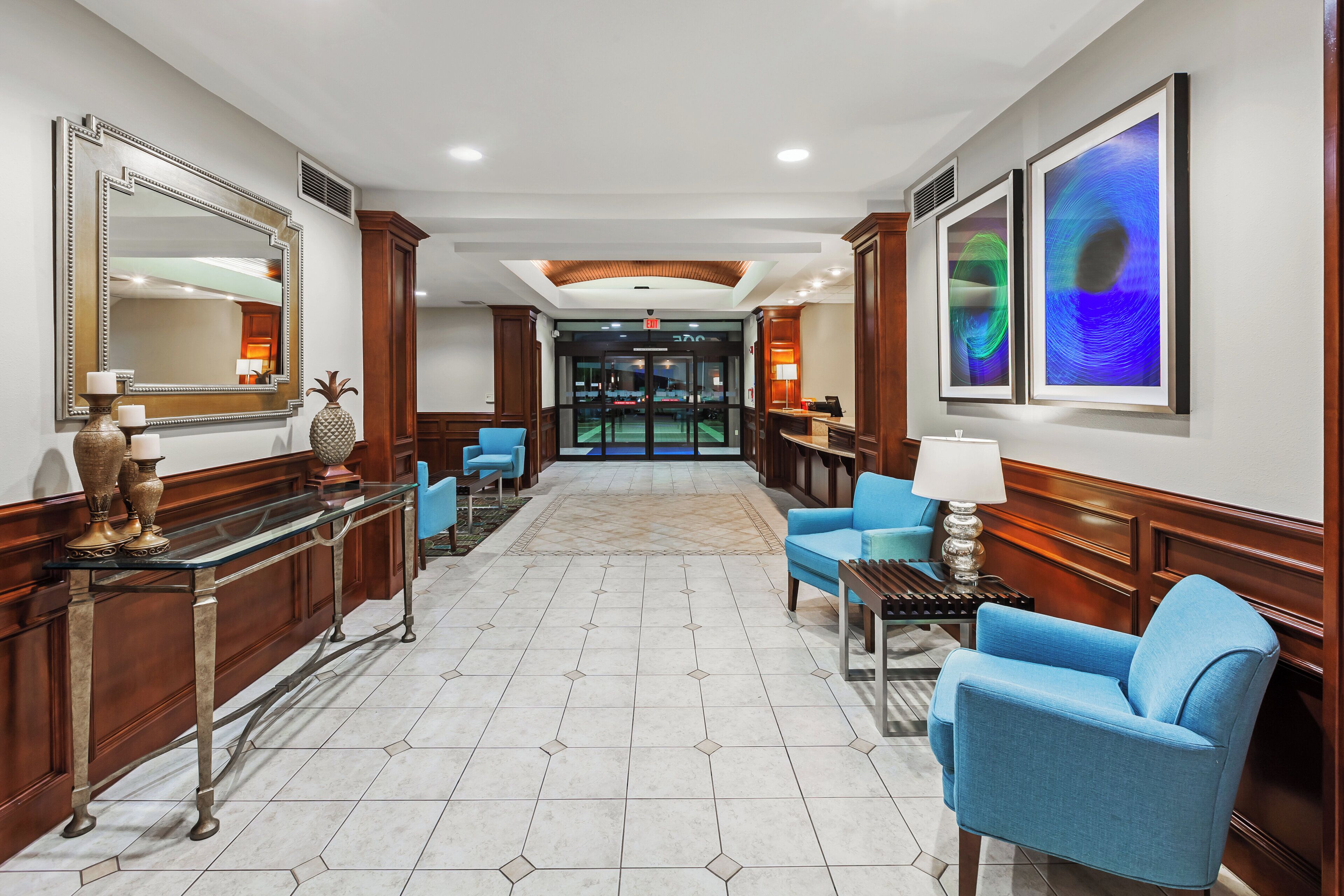 A hotel lobby with a reception desk, seating area, and a view into the hotel's interior.