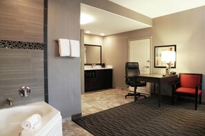 A hotel bathroom with a bathtub, a sink, and a mirror.
