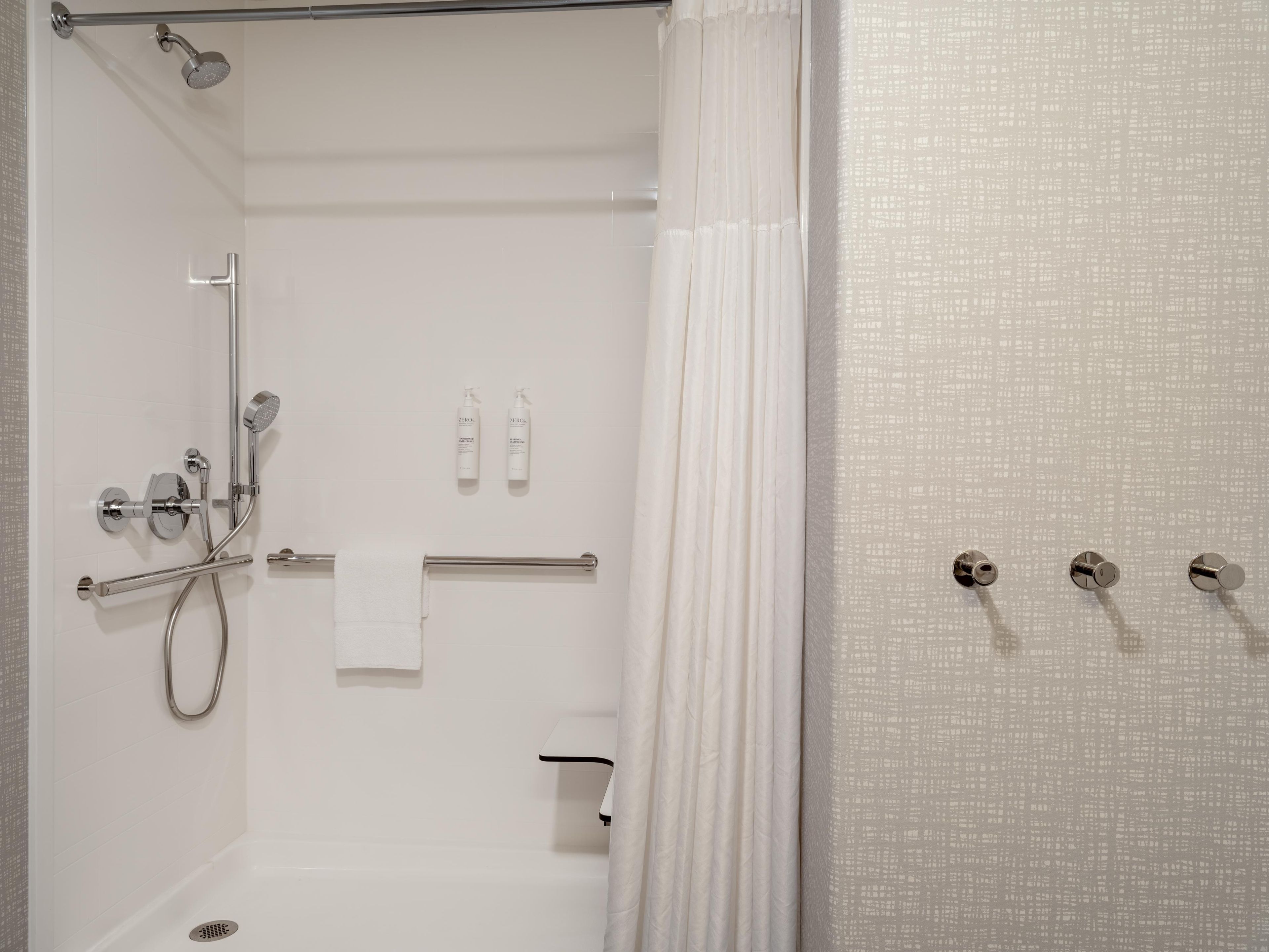 Un baño moderno con ducha, inodoro y perchero para toallas.