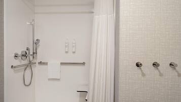 Un baño moderno con ducha, inodoro y perchero para toallas.
