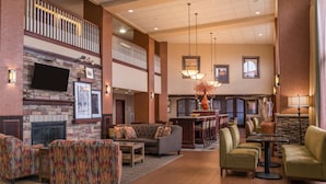 A spacious lobby with a fireplace, seating area, and a balcony. - Hampton Inn & Suites Boise-Meridian (Meridian)