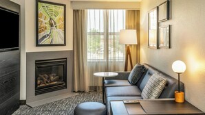 A modern hotel room with a fireplace, a sofa, a TV, and a large window with curtains. - Residence Inn by Marriott Rochester Mayo Clinic Area (Rochester)