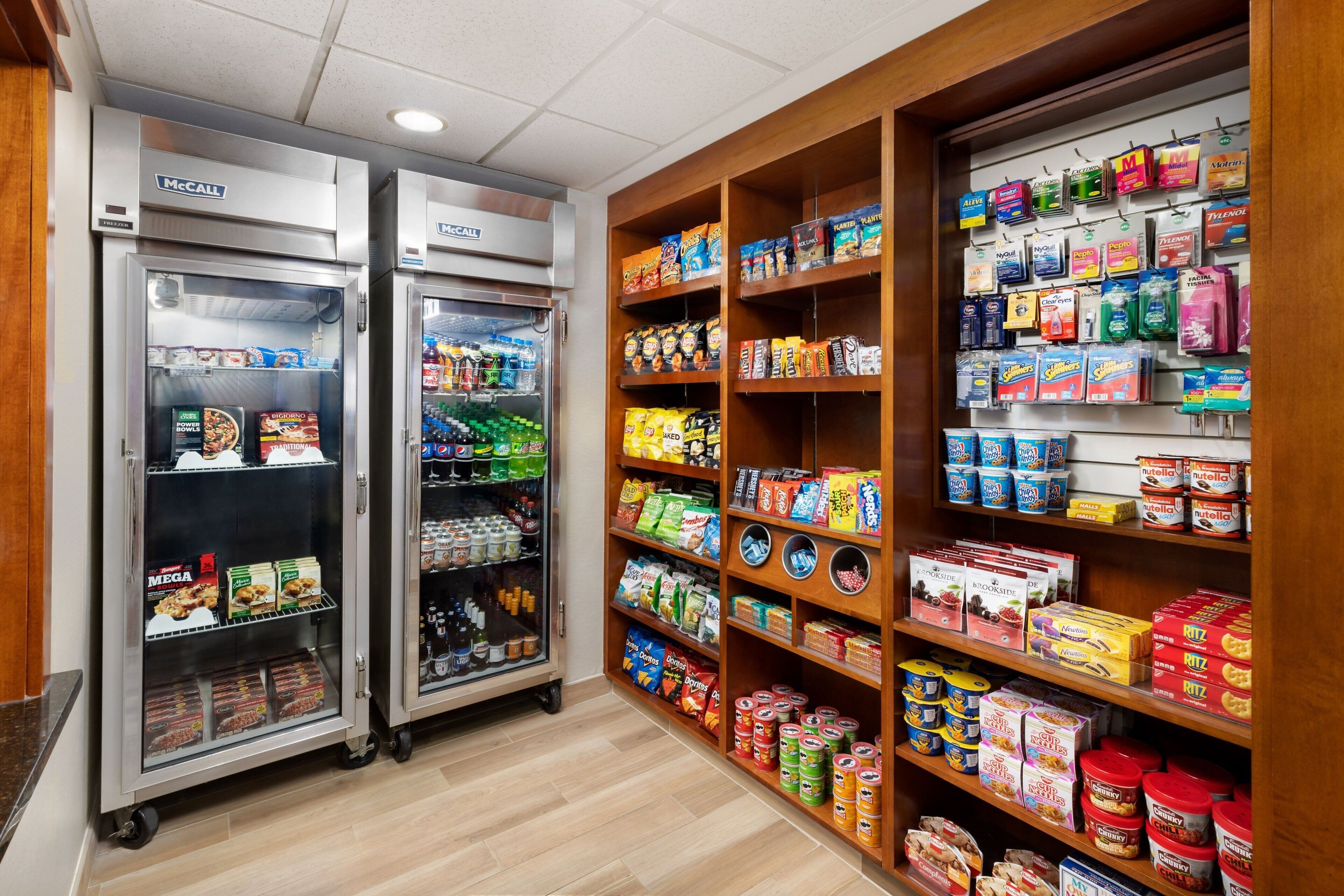 A self-service food area with refrigerated cases and shelves stocked with snacks and beverages.
