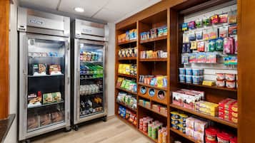 A self-service food area with refrigerated cases and shelves stocked with snacks and beverages.