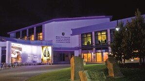 Un edificio moderno con un letrero que indica Macdonald Hotels & Resorts, Centro de Conferencias Aviemore Highland.