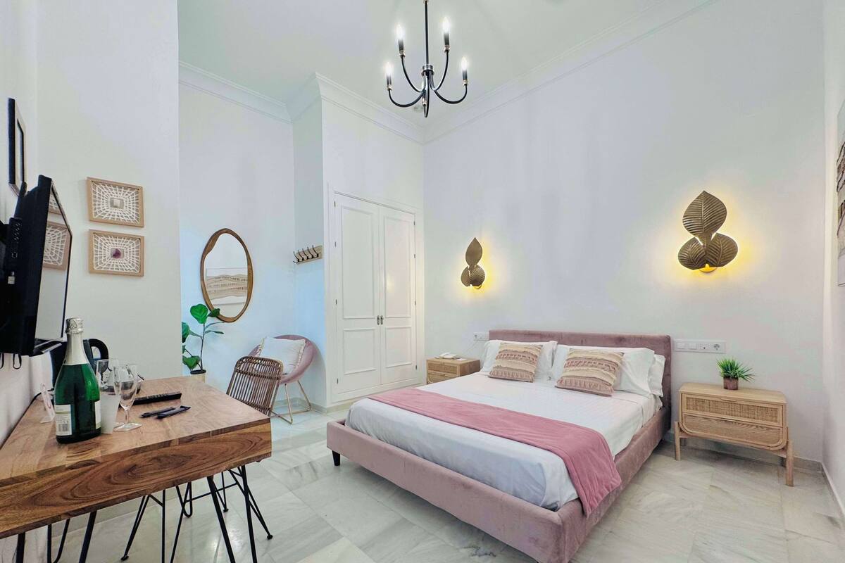Een moderne slaapkamer met een groot bed, een bureau, een stoel en een kledingkast.