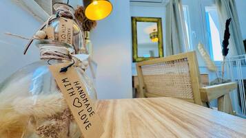 A clear glass bottle with a tag reading "HANDMADE WITH LOVE" on a wooden surface.