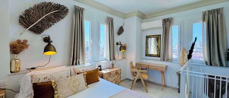 Un dormitorio moderno con una cama grande, un escritorio y vistas a la ciudad.