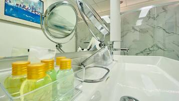 A bathroom with a sink, mirror, and toiletries.