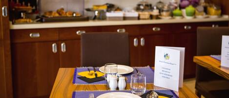 A breakfast buffet setup with a variety of food items and a sign indicating breakfast options.