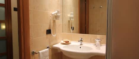 Une salle de bain avec un lavabo, un miroir et une douche.